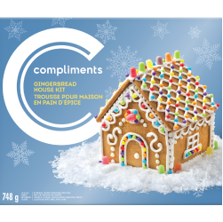Gingerbread house kit decorated with royal icing and gum drops on blue box.