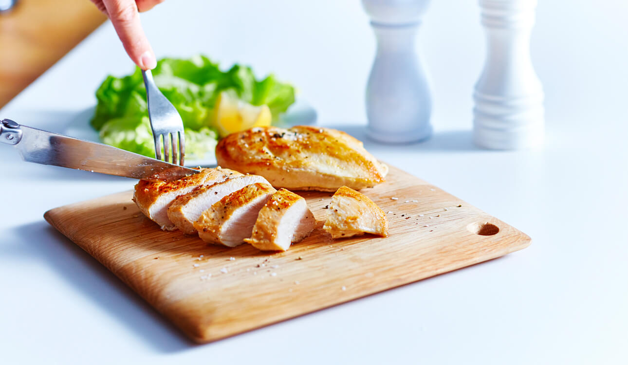 Poitrine de poulet tranchée sur une planche à découper